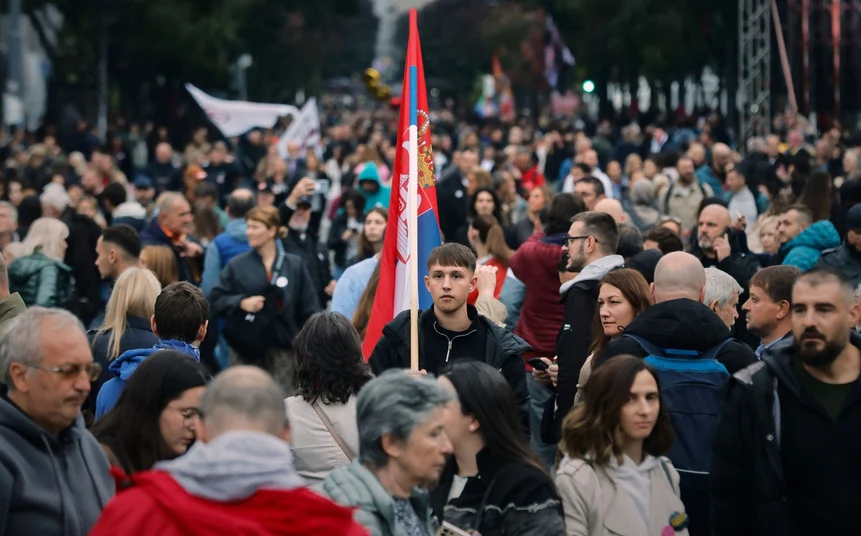 Jovem segurando bandeira em meio a multidão em manifestação